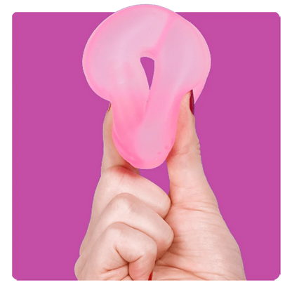 A translucent pink silicone adult novelty item held between fingers against a solid magenta background.