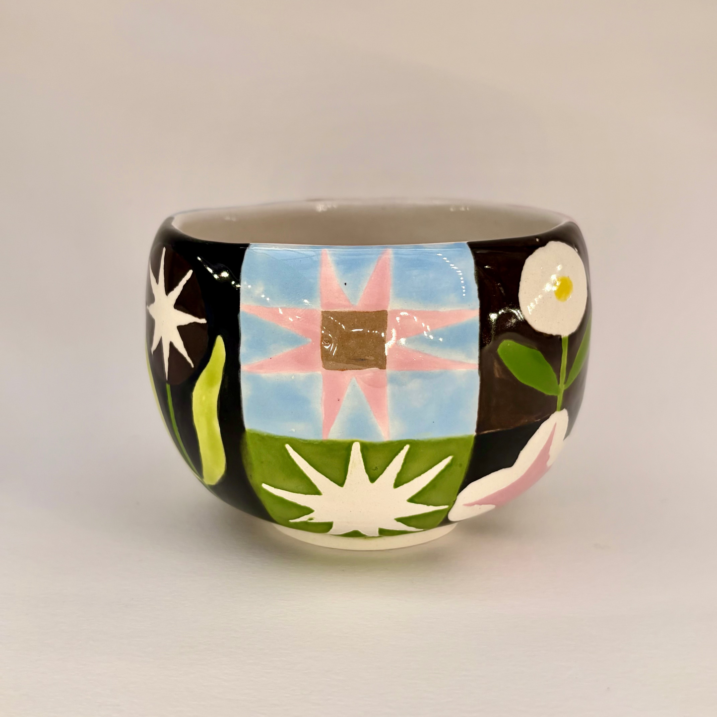 Ceramic mug with colorful abstract design on a plain background