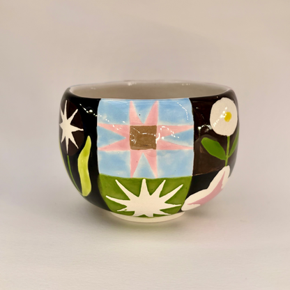 Ceramic mug with colorful abstract design on a plain background