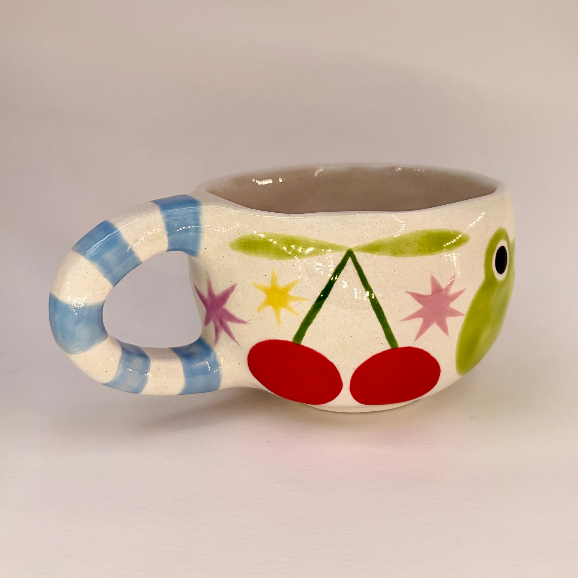Ceramic mug with colorful design on a plain background