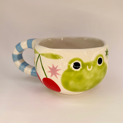 Ceramic mug with a frog design on a plain background