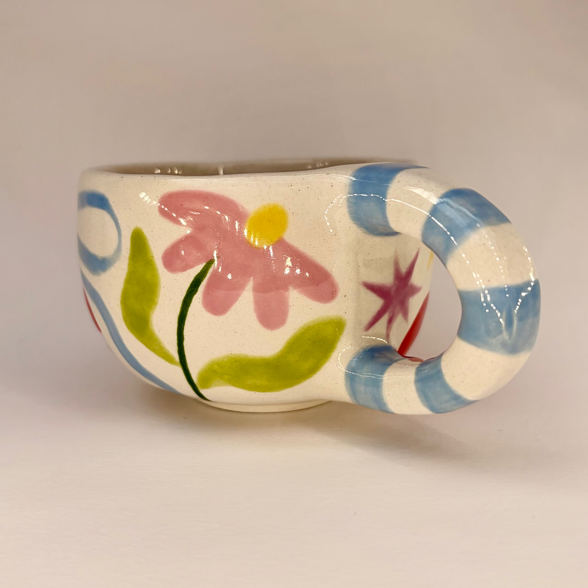Ceramic mug with floral design on a plain background