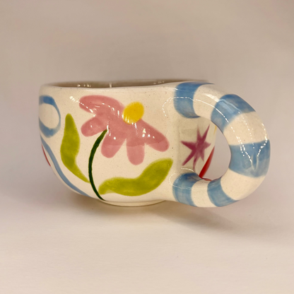 Ceramic mug with floral design on a plain background