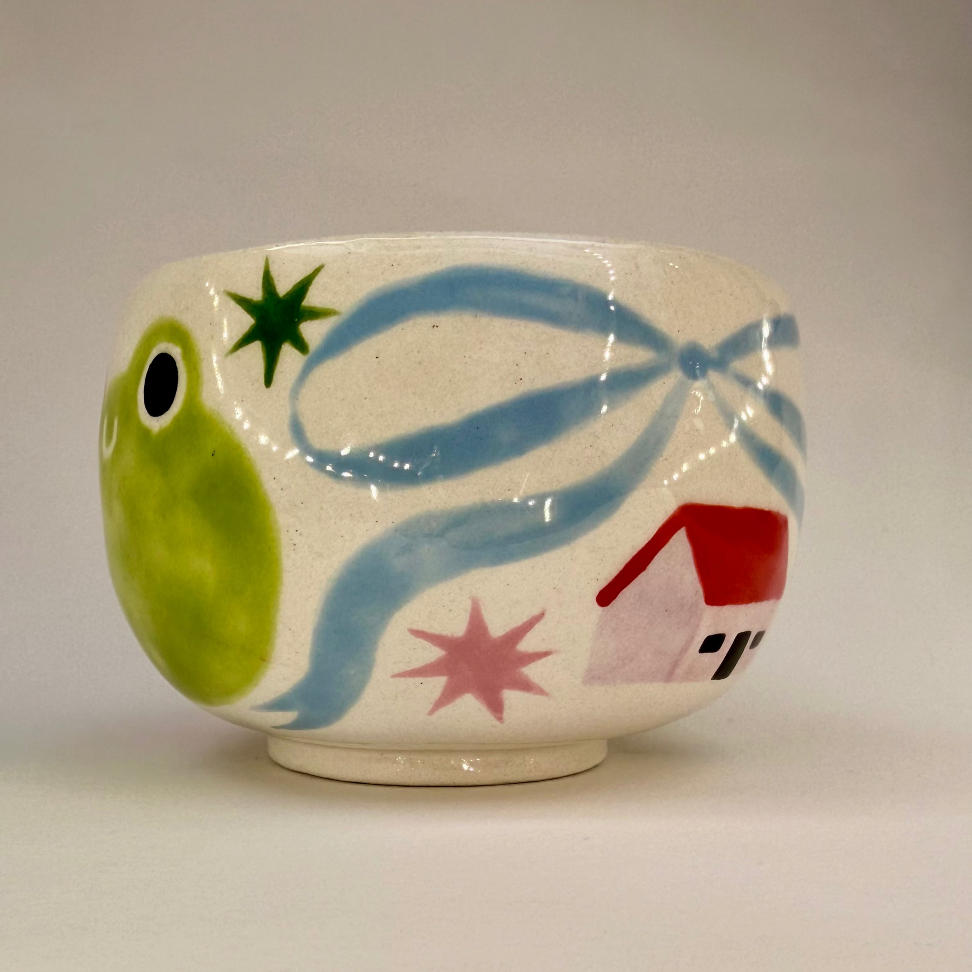 Ceramic mug with colorful designs on a plain background