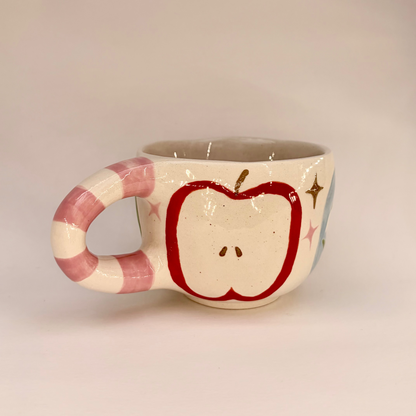 Ceramic mug with apple design on a beige background