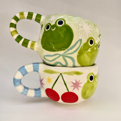 Colorful ceramic mugs with frogs