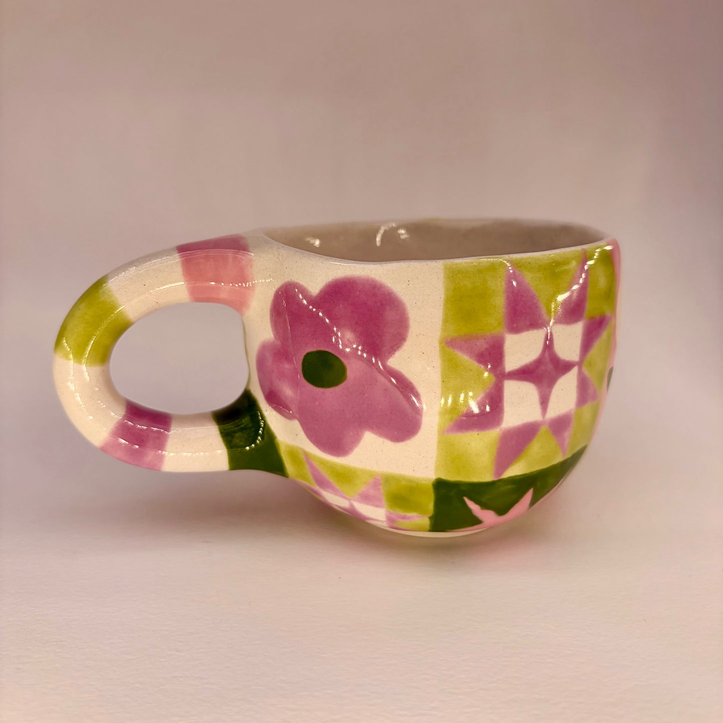 Ceramic mug with floral design on a plain background
