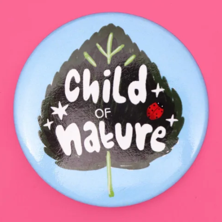 Button badge with 'Child of Nature' text on a leaf design against a pink background