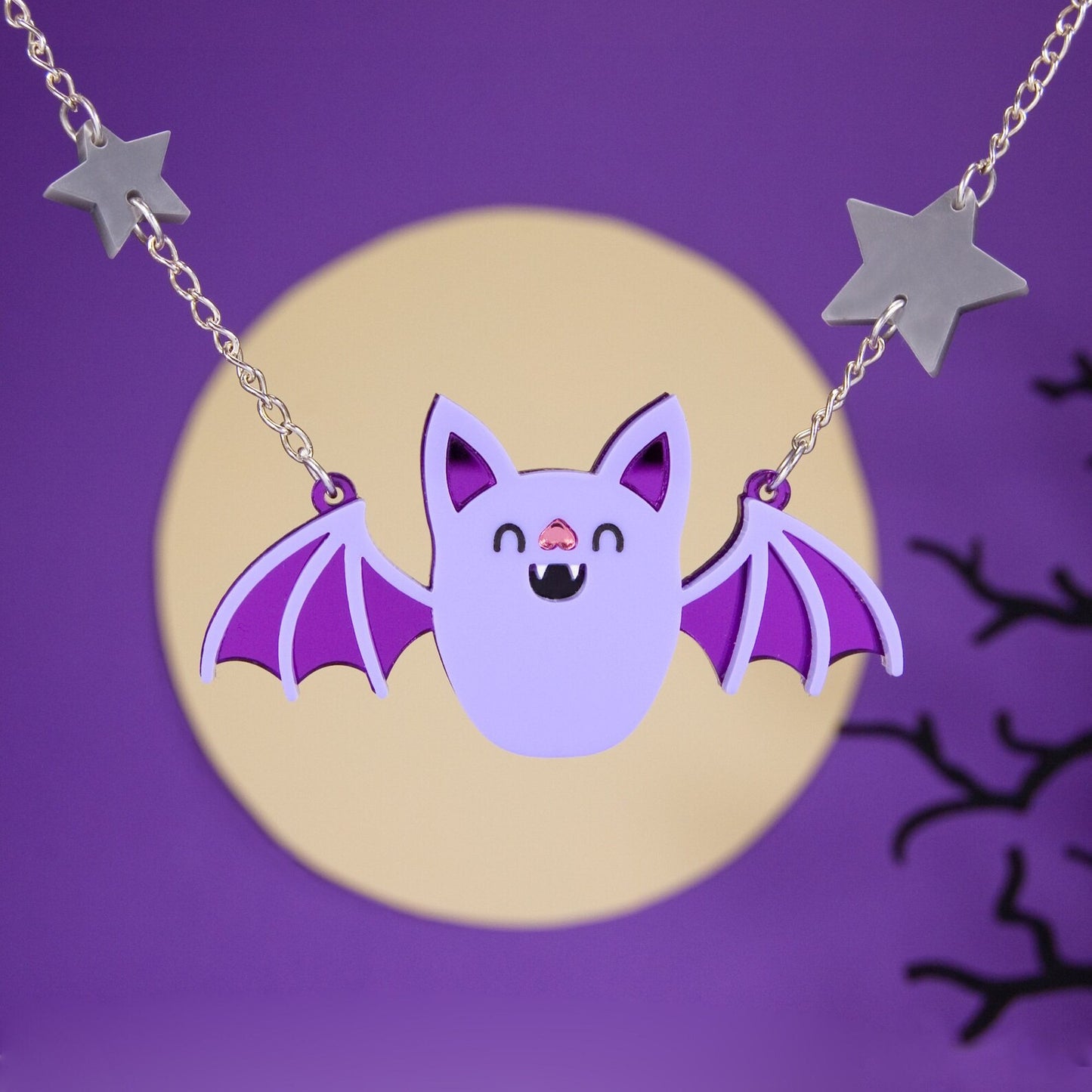 Necklace with a large cartoon bat pendant, and grey stars on the chain against a purple background