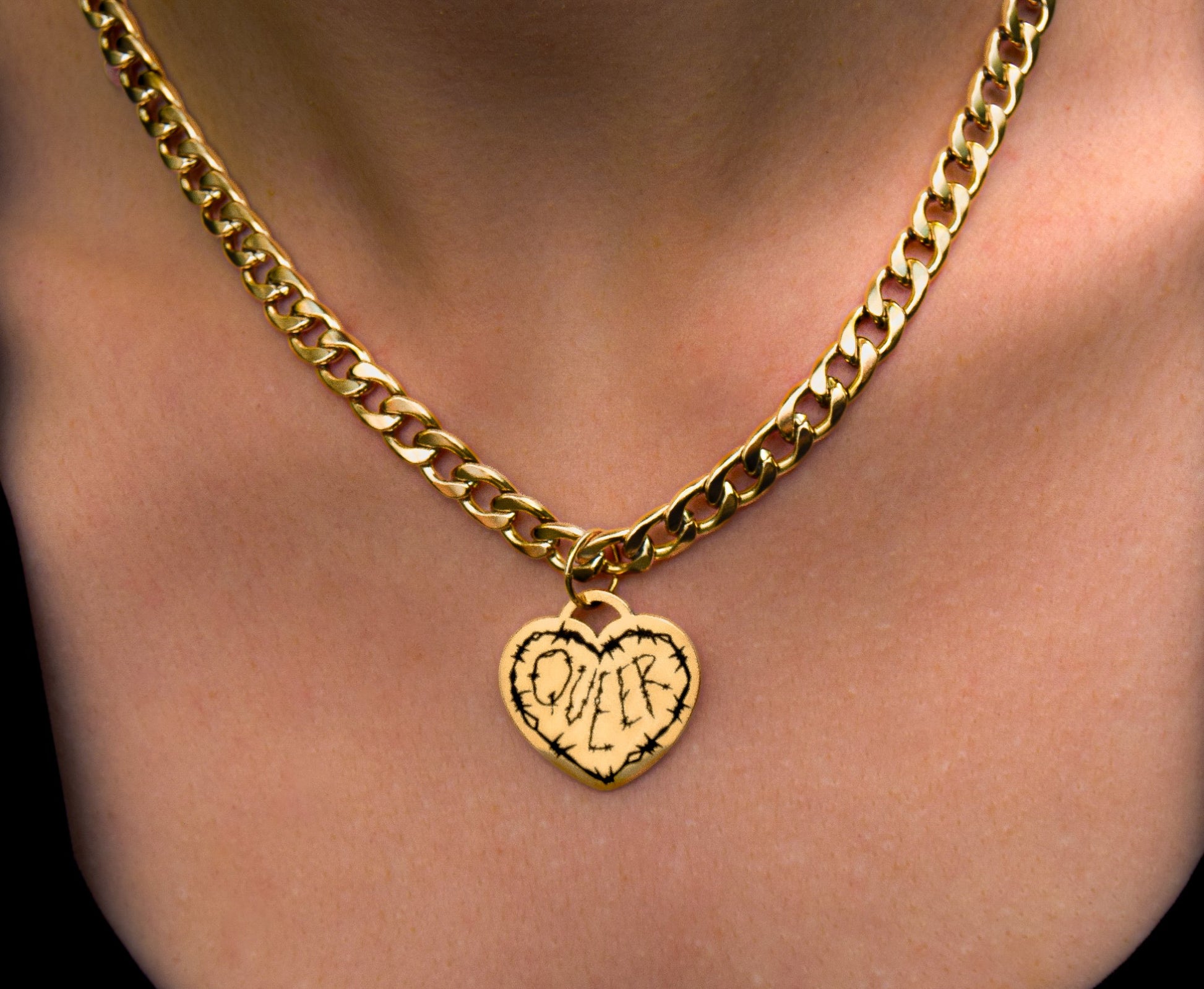 Gold chain necklace with a heart-shaped pendant on a person's neck