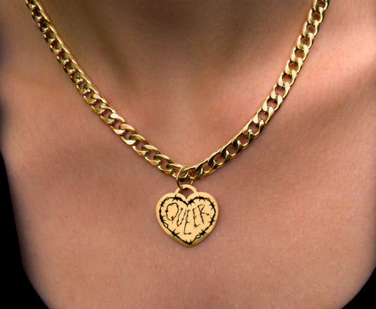 Gold chain necklace with a heart-shaped pendant on a person's neck